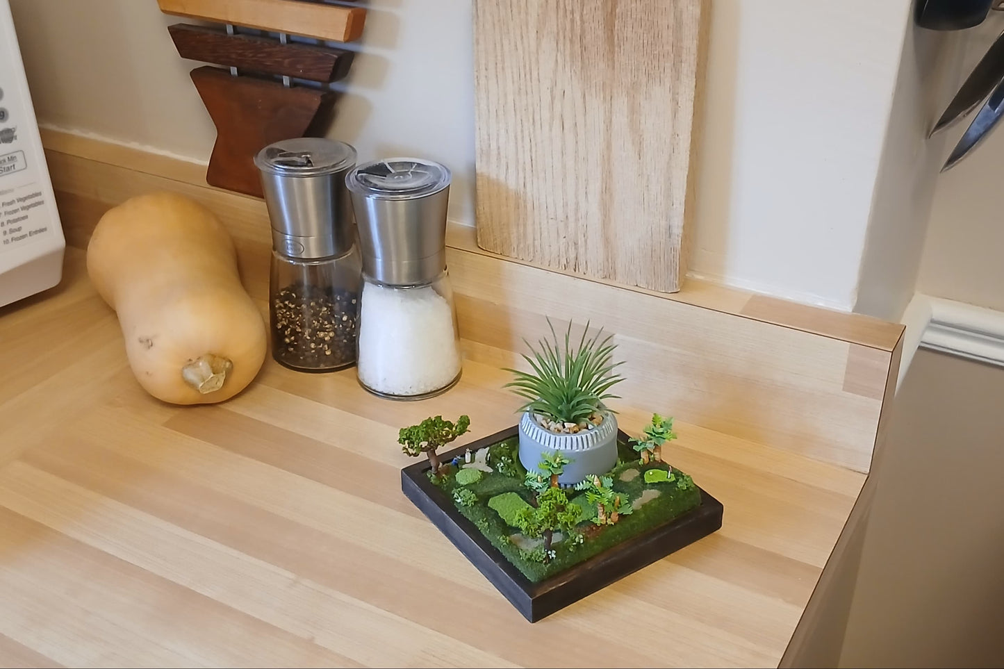 Miniature model of a golf course with trees, sand traps, clubs on a wooden base. Pot holder, model display, candle holder, diorama.