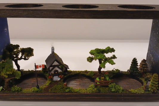 Handmade three glass tube wooden base propagation system. Miniature model chalet and garden scene with realistic trees and Canadian flag.  