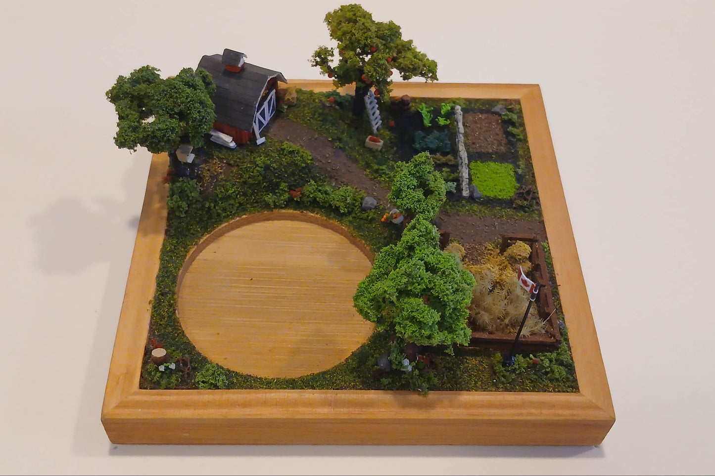 Miniature model farm scene with barn, trees, garden, field and pathways mounted within a wooden base  Pot holder, model display, candle holder, diorama