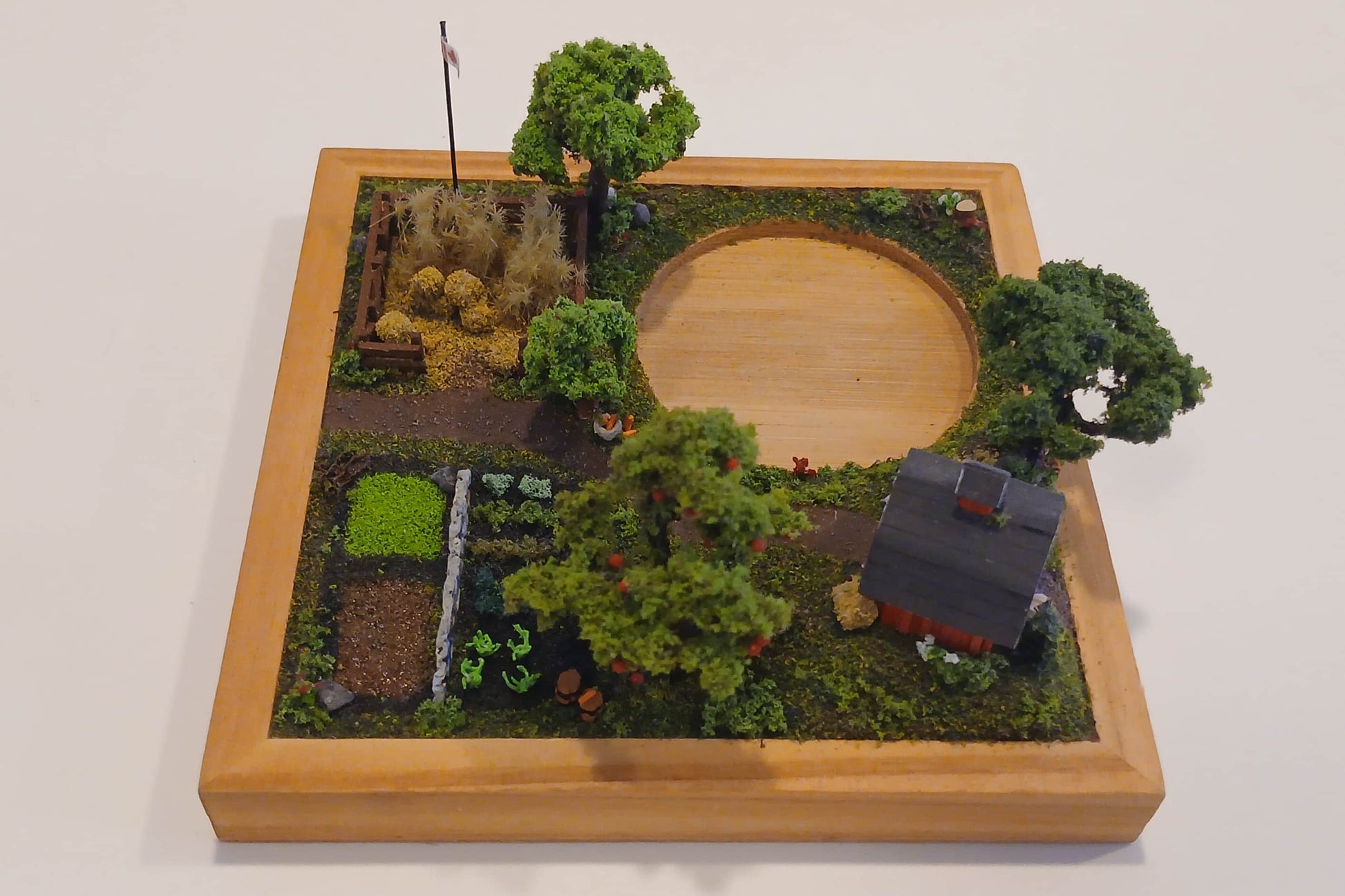 Miniature model farm scene with barn, trees, garden, field and pathways mounted within a wooden base  Pot holder, model display, candle holder, diorama